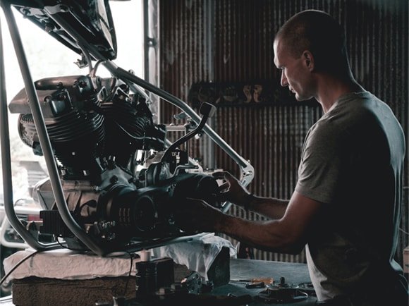 Mecânico experiente a reparar motor numa oficina em Portugal no Dia do Trabalhador.